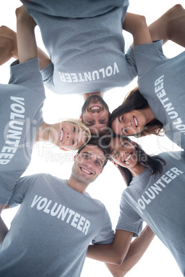 Happy volunteers forming huddle