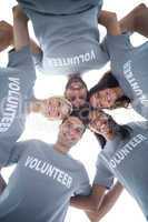 Happy volunteers forming huddle