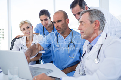 Doctor showing laptop pc to his colleagues