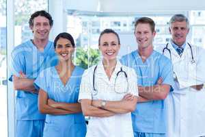 Team of doctors standing arms crossed and smiling at camera