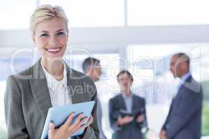 Businesswoman holding tablet and looking at camera