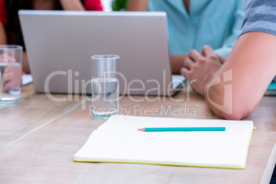 Close up of notebook and laptop in meeting