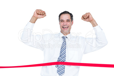 Happy businessman cutting red ribbon