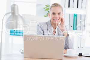 Smiling businesswoman using her computer