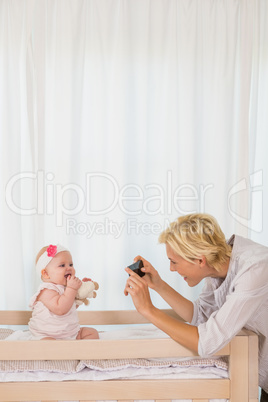 Happy mother taking a picture of her baby girl