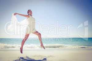 Peaceful brunette jumping at the beach