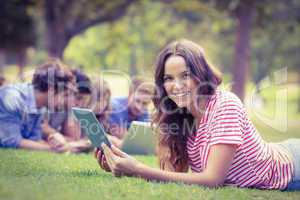 Pretty brunette using tablet in the park