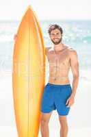 Handsome man holding surfboard