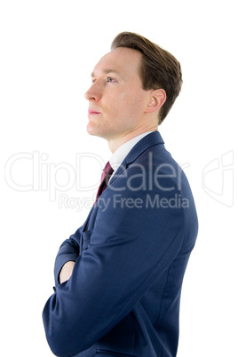 Thoughtful businessman looking away with arms crossed