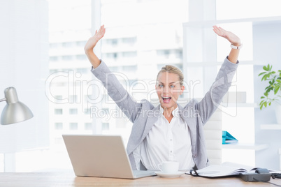 Happy businesswoman with raised arms