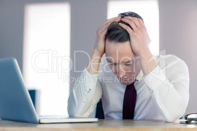 Worried businessman with head in hands