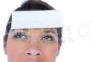 Pretty brunette looking at camera with paper on head