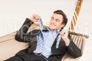 Businessman removing his tie on the hammock