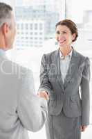 Smiling businesswoman shaking hand with a businessman