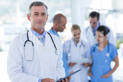 Doctor looking at camera while his colleague discussing Doctor looking at camera while his colleague discussing