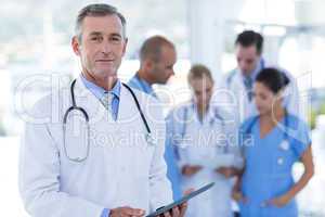 Doctor looking at camera while his colleague discussing