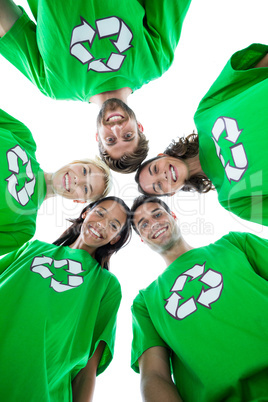 Friends wearing recycling tshirts forming huddle