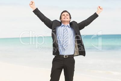 Happy businessman cheering at the beach Happy businessman cheering at the beach