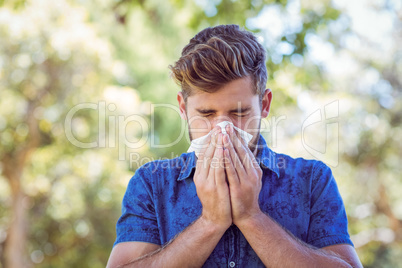Handsome hipster blowing his nose