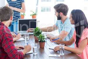 Colleagues using laptop at office