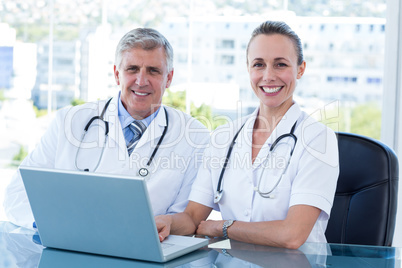 Smiling doctors working together on laptop Smiling doctors working together on laptop