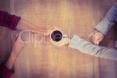 Two hands warming a cup of coffee