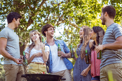 Happy friends in the park having barbecue