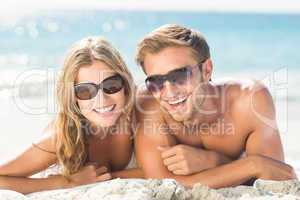 Happy couple relaxing together in the sand