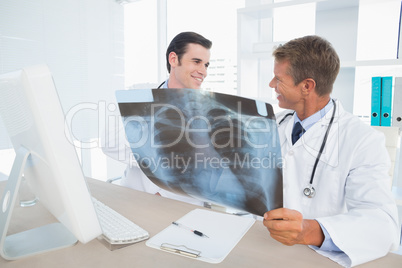 Smiling doctors looking at Xray