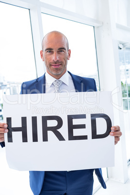businessman holding a hired sign