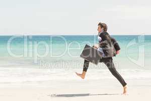 Businessman jumping in front of the sea