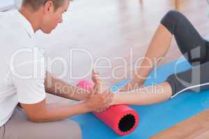 Trainer working with woman on exercise mat