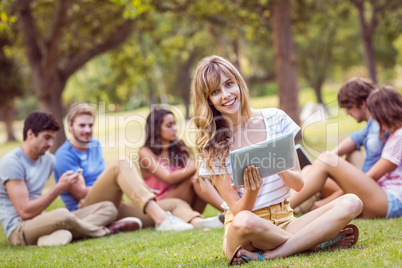 Pretty blonde using tablet in the park