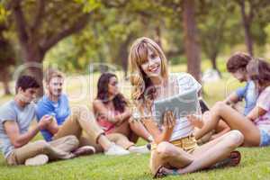 Pretty blonde using tablet in the park