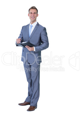 Happy businessman holding clipboard and writing notes