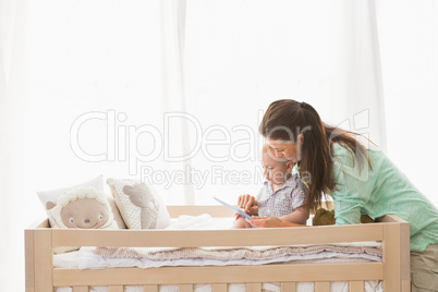 Happy mother using tablet with his baby boy