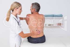 Doctor examining her patient back