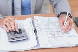 Businessman using calculator to calculate finance