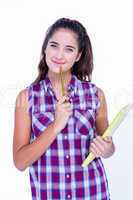 Pretty brunette looking at camera and holding notebook