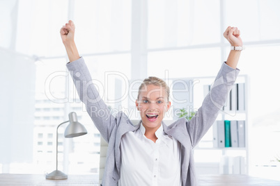 Happy businesswoman with raised arms