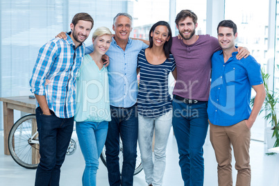 Happy business team with arms around in office