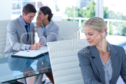 Businesswoman whispering something to her colleague