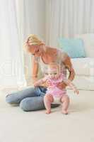 Happy blonde mother playing with her baby girl