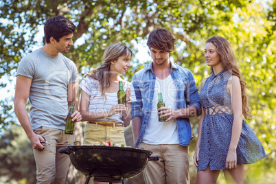 Happy friends in the park having barbecue