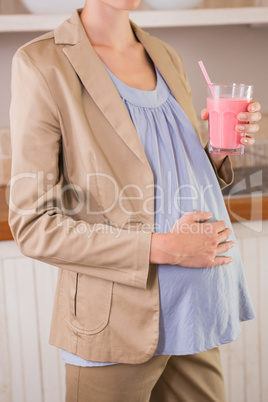 Blonde pregnancy drinking a smoothie