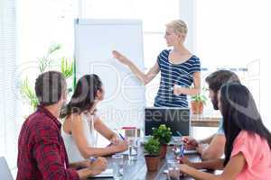 Casual businesswoman giving presentation to her colleagues