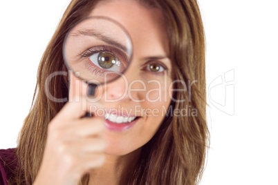 Smiling woman looking through magnifying glass