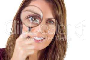 Smiling woman looking through magnifying glass