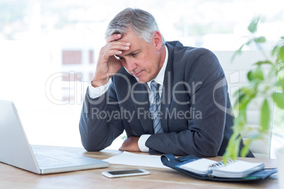 Worried businessman with head in one hand