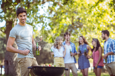 Happy friends in the park having barbecue